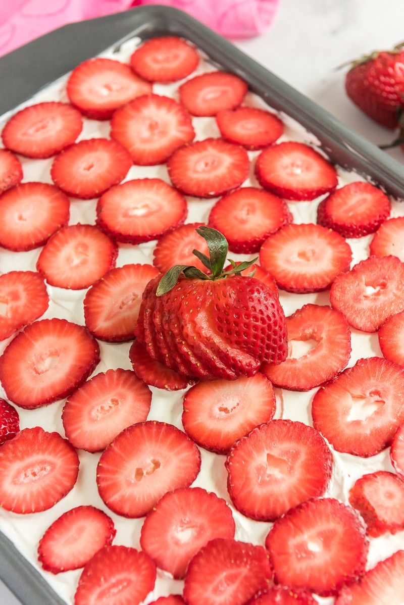 Τεμαχισμένες φράουλες πάνω από ένα κέικ φράουλας