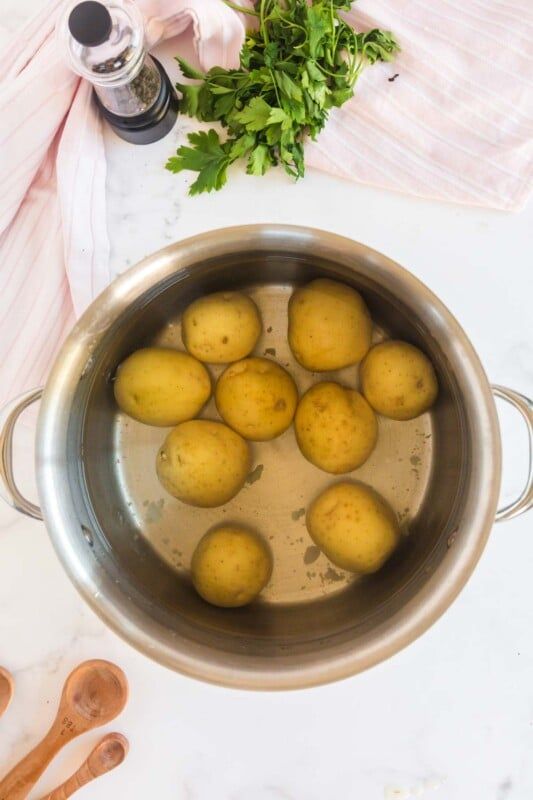 Kovinski lonec z rumenim krompirjem v notranjosti