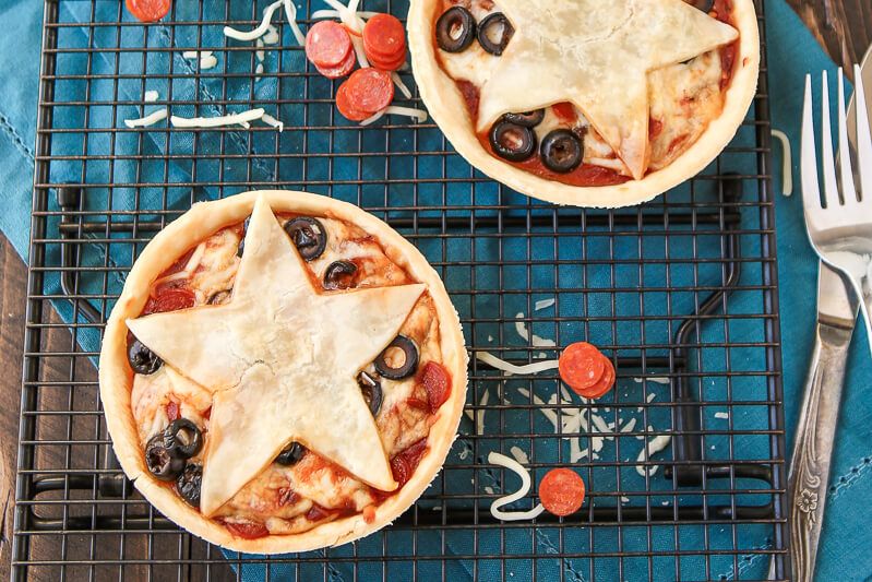 Тези мини пайове за пица са идеални за всеки, който обича момичетата от Гилмор, пица или пай! Любимите ви заливки за пица, изпечени на коричка за пай, правят тези почти като версия на пай от любимите ви пилешки ролки. Такава лесна рецепта за пай с пица и аз обожавам звездата Stars Hollow отгоре! Определено добавям това към моя лесен борд за мезета!