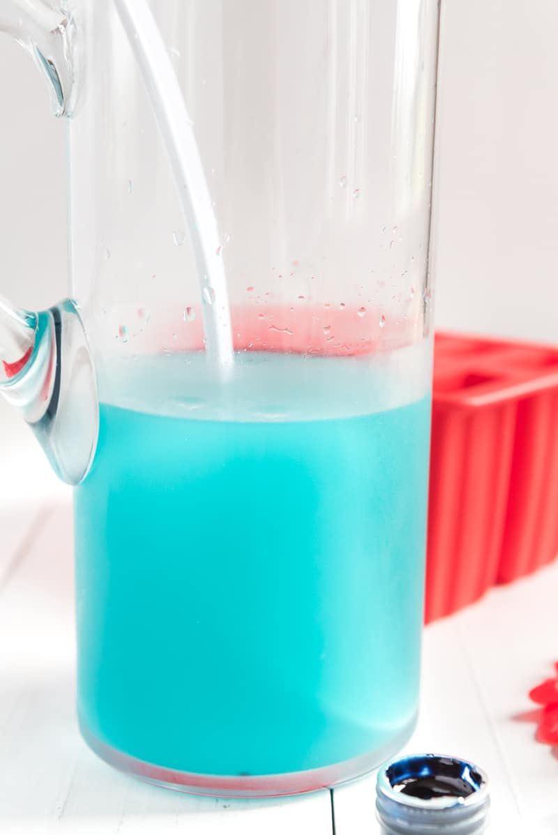 Una jarra de vidrio con limonada azul en el interior.