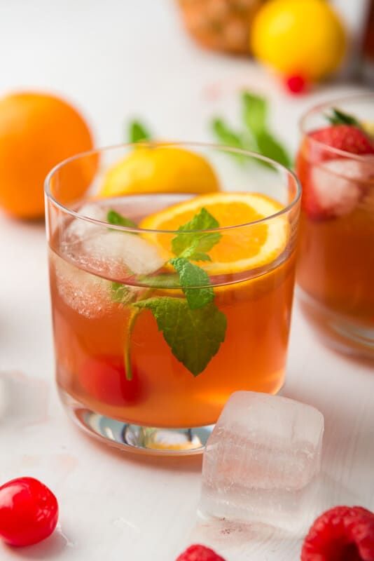 Een glas zelfgemaakte fruitpunch met sinaasappels en ijsblokjes