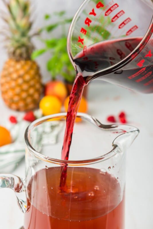 Verter jugo de uva en una jarra de vidrio