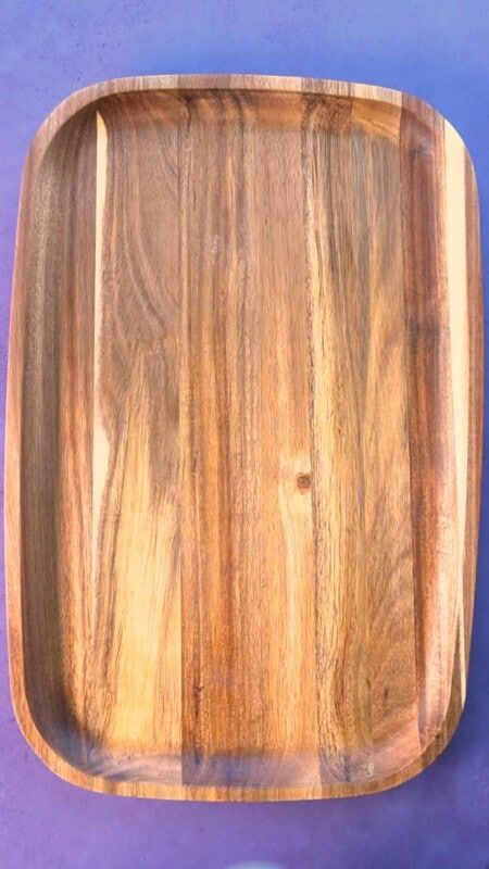 Una tabla de madera sobre un fondo morado.