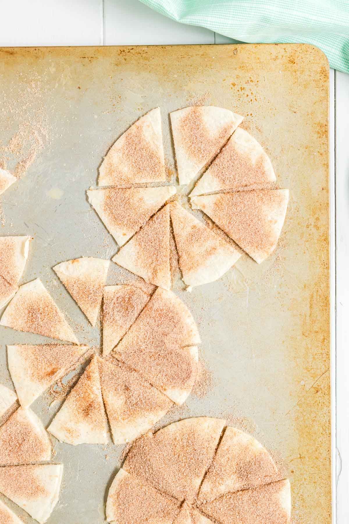 Tortiljas sagriež trijstūros un pārklāj ar kanēļa cukuru