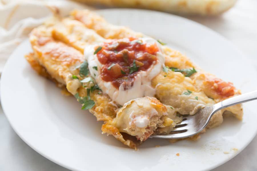 Egy tányér kanállal tele fehér csirke enchiladas