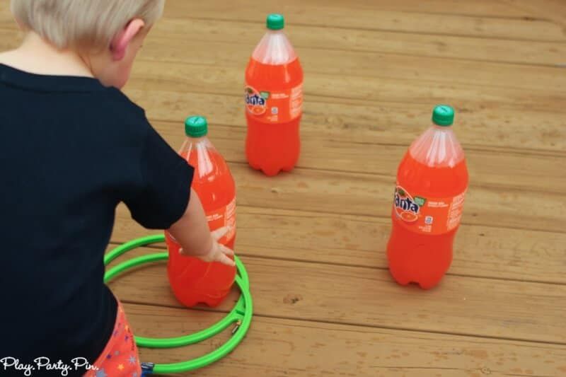 Lanzamiento de anillos de dos litros con botellas de Fanta naranja para un divertido juego de fiesta de Halloween