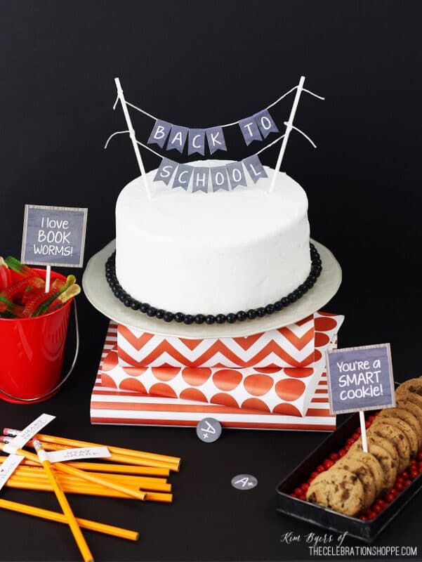 Белый торт, карандаши и подставка для торта с распечатками на классной доске