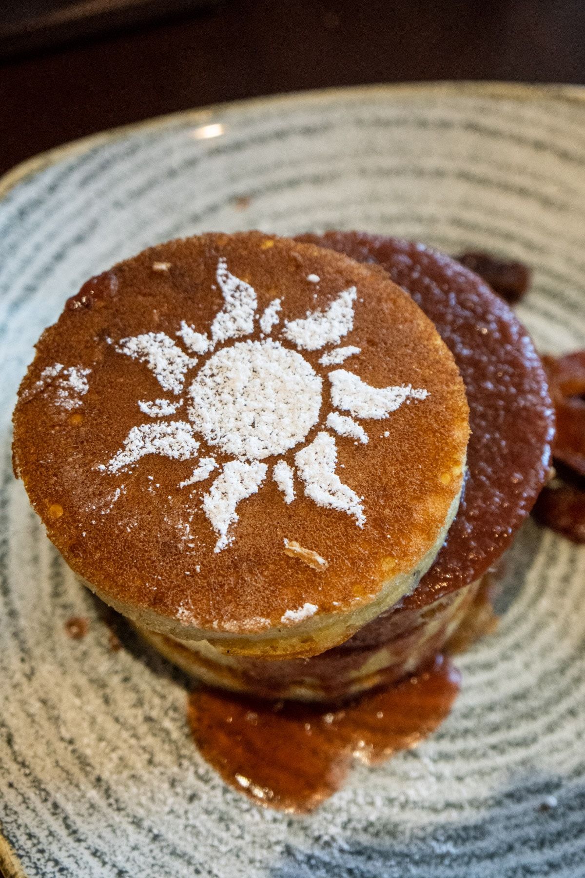 Mga pancake na may isang simbolong gusot sa itaas na may pulbos na asukal