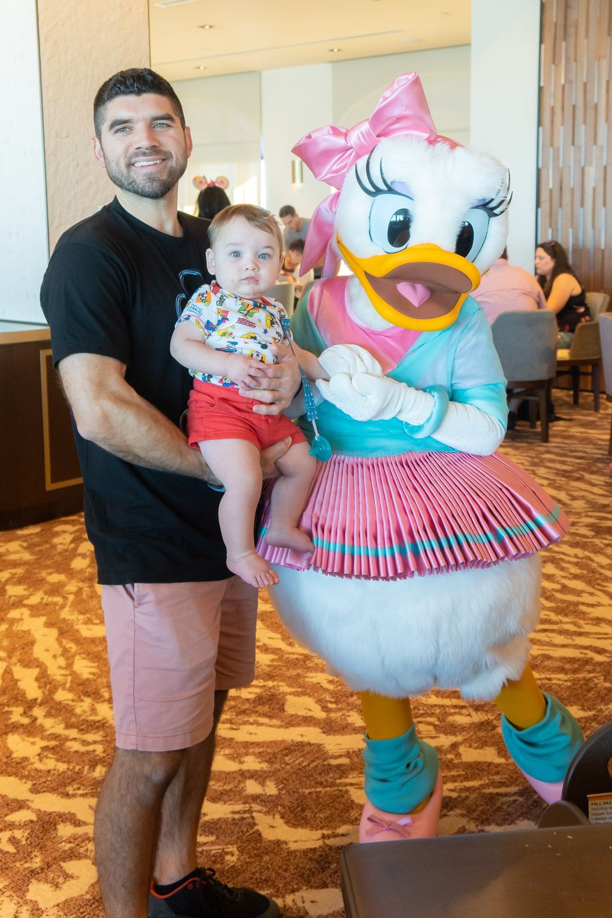 Vīrietis un mazulis ar Daisy Duck balerīnas kostīmā