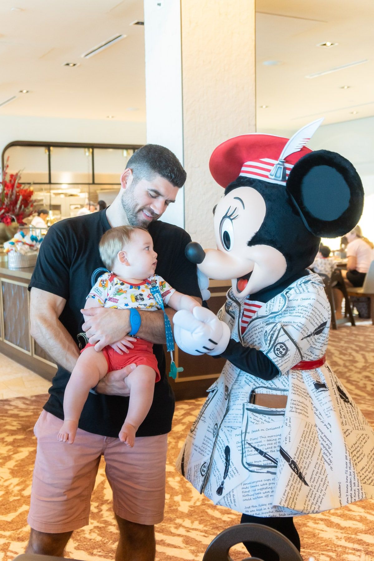 Mies ja vauva Minnie Mouse -hiiren kanssa