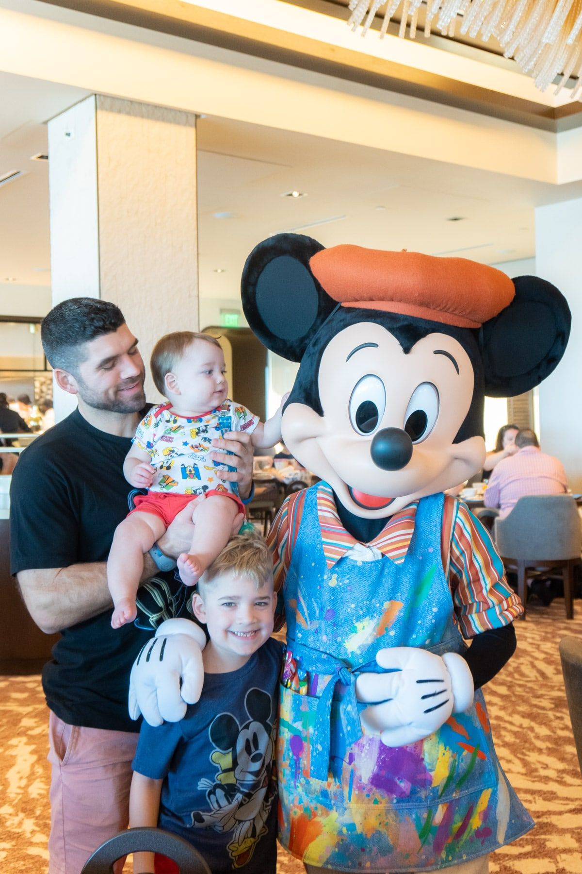 Perhe Mickey Mousen kanssa taidemaalarissa