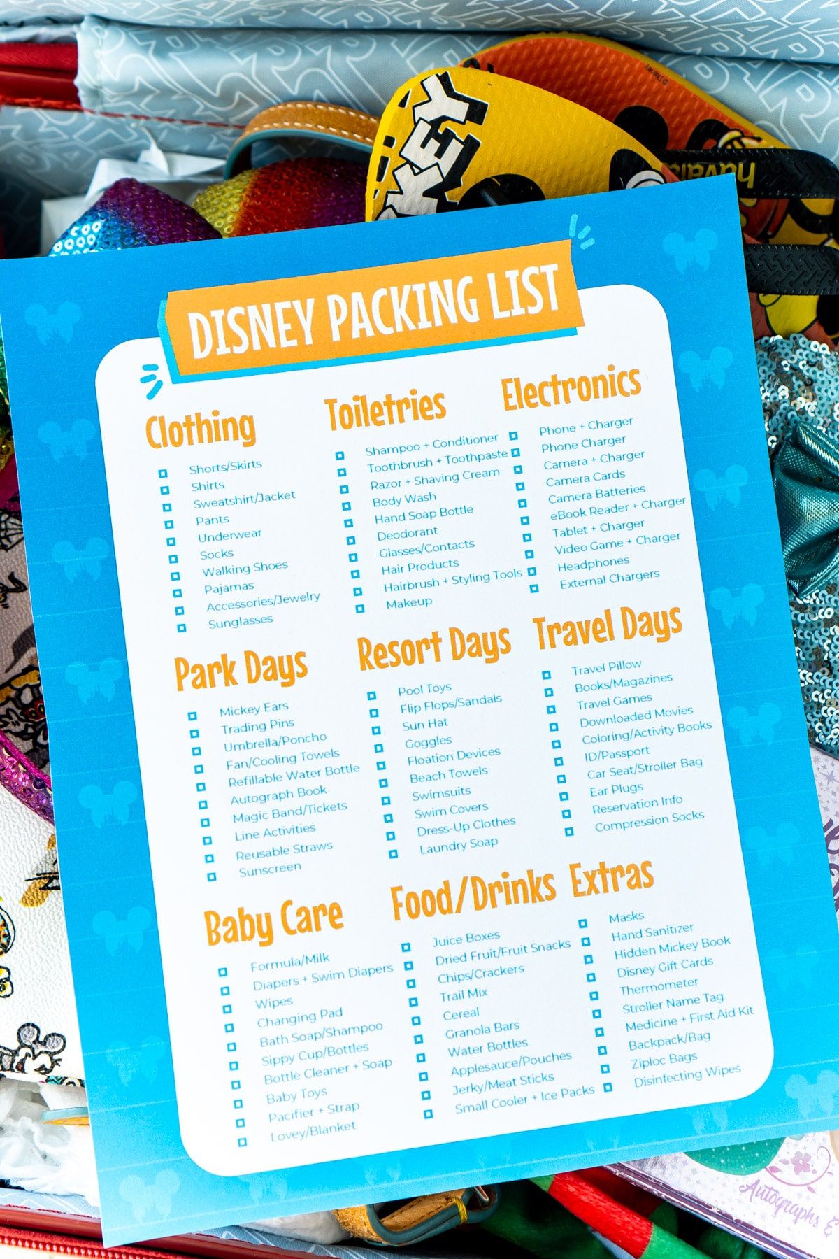 Lista de embalagem da Disney com fundo azul em uma mala Disney